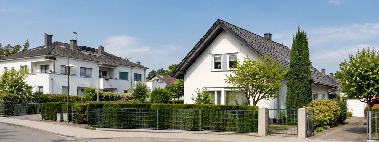 Normale Wohnliegenschaften mit Haus, Mehrparteienhaus und sichtbaren Grundstücksgrenzen